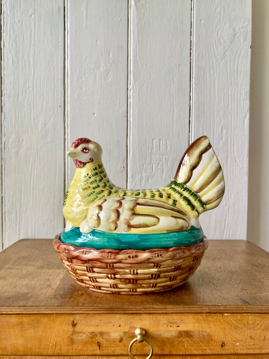 A decorative hand painted chicken egg tidy, sitting on her nest