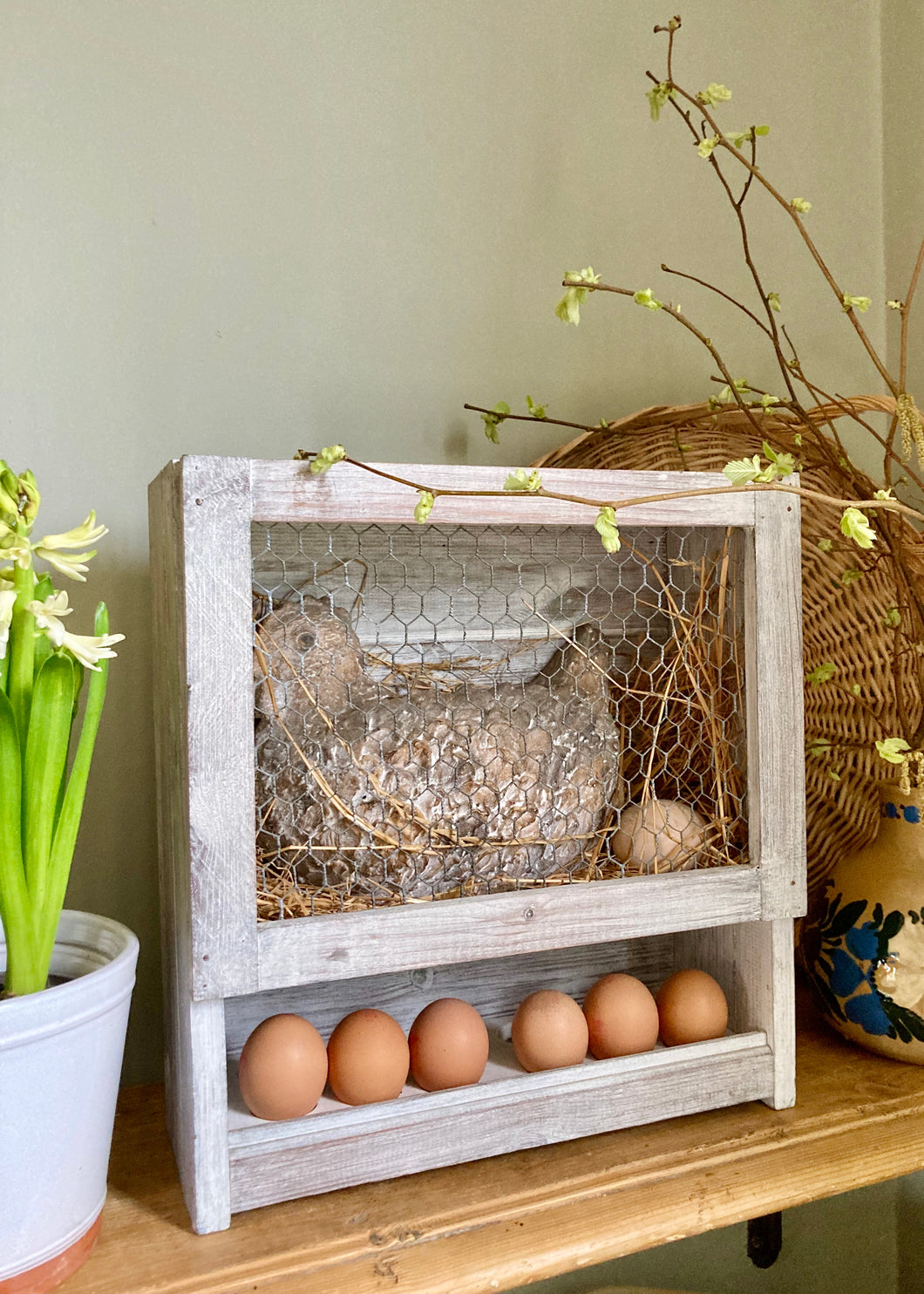 Artisan-made, pottery chicken in nesting box with egg storage rack